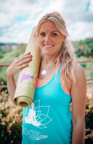 Yogalehrerin Petra Lösch hält eine Yogamatte