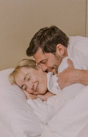Paar kuschelt im Bett