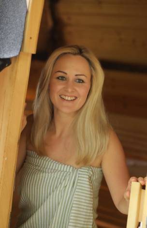 Frau betritt eine Fasssauna 