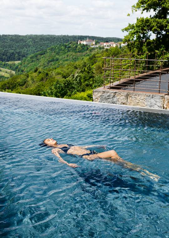 Frau badet im Infinity-Waldpool des Mawell Resort