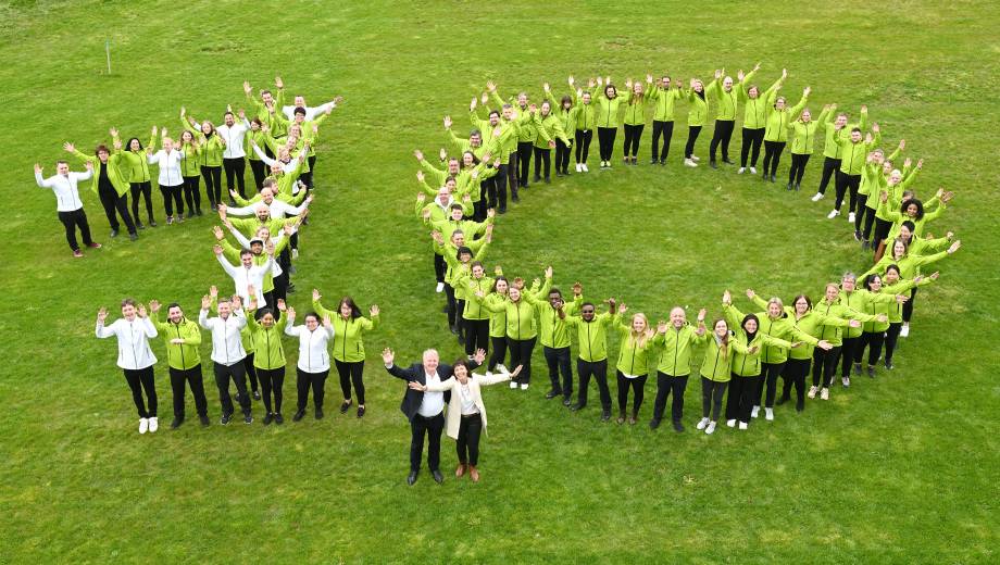 Das Mawell Team steht auf einer Wiese und bildet eine 10