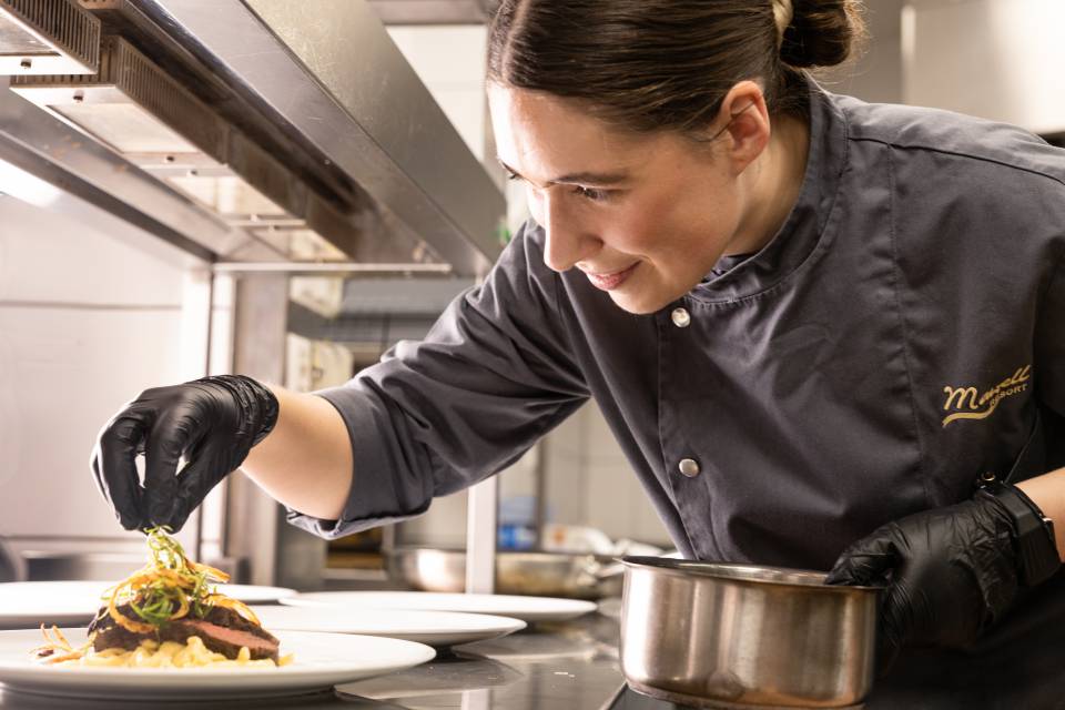 Köchin richtet ein Gericht an