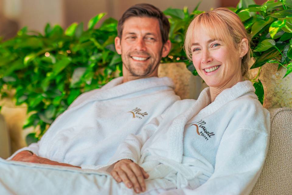 Paar entspannt im Bademantel im Wellnessbereich