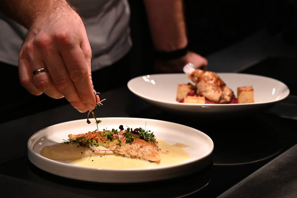 Koch bereitet Fleisch und Fischgerichte zu