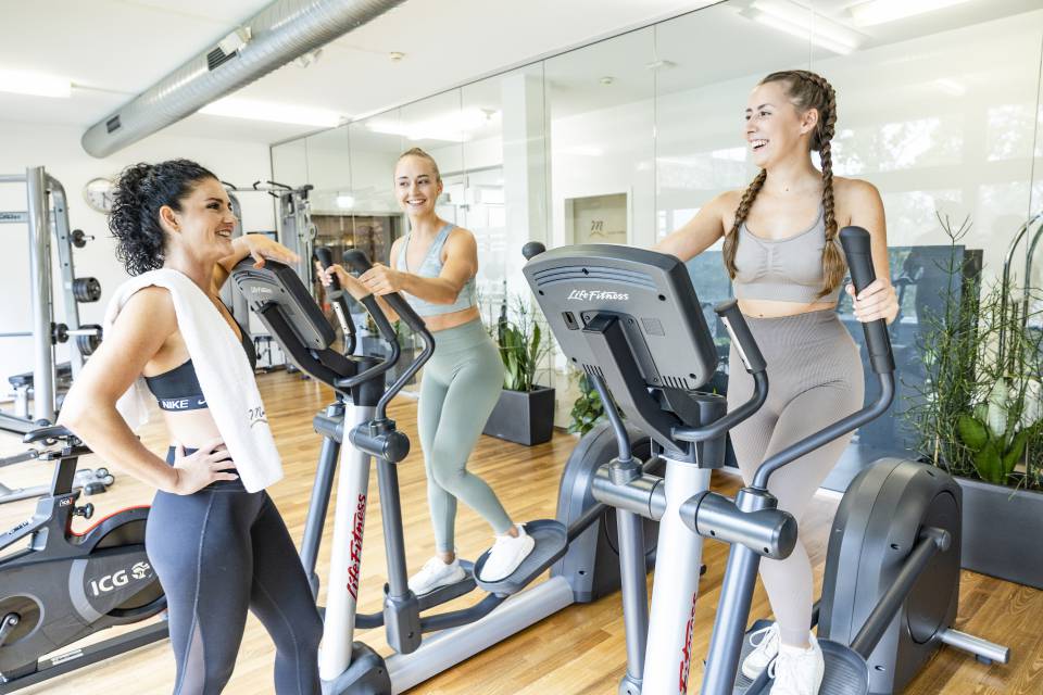 Frauen im Fitnessstudio auf dem Crosstrainer