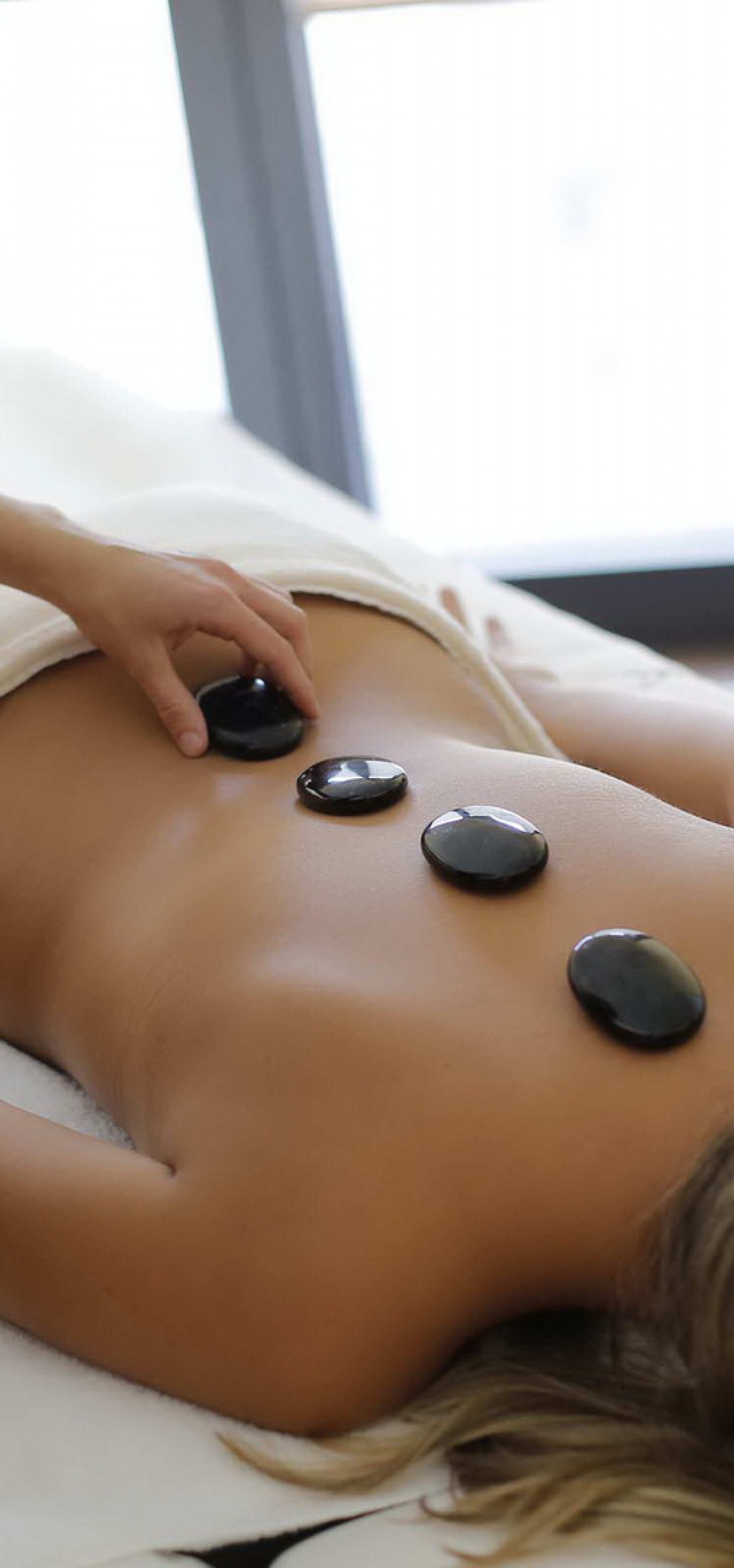Frau erhält eine Hot Stone Massage